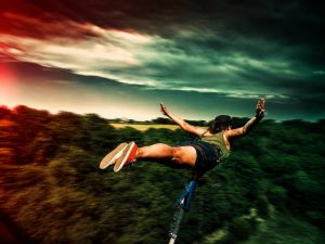 Participante équipée pour un saut à l’élastique face à un panorama naturel